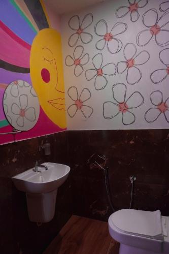 a bathroom with a sink and a flower mural on the wall at Vrindavan homestay in Munroe Island