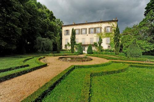 a garden with a large building and a fountain at Chateau De La Chassaigne in Thiers