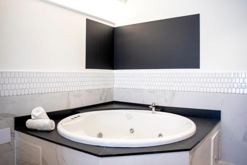 a white bathroom with a bath tub on a counter at Citrea Santander in Santander