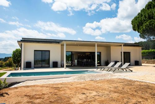 une maison avec une piscine et deux chaises longues dans l'établissement Villa des pins - sud Ardèche 4 lits - 6 pers, à Lablachère