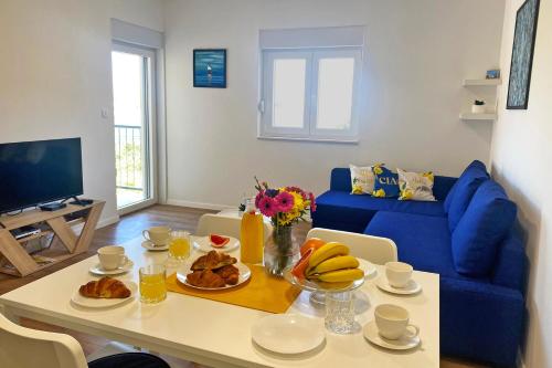 a living room with a table with food on it at Apartmani Portina in Baćina