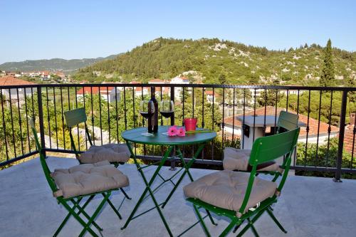 a patio with a table and chairs on a balcony at Apartmani Portina in Baćina