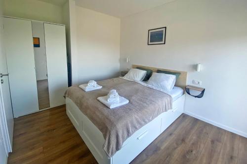 a bedroom with a bed with two towels on it at Apartmani Portina in Baćina