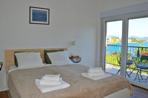 a bedroom with a bed with white towels on it at Apartmani Portina in Baćina
