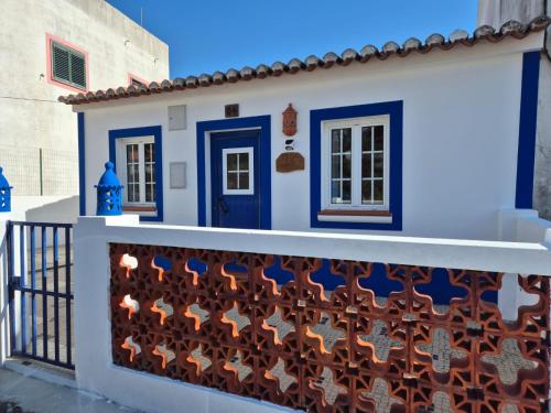 a house with a blue door and a fence at Casa da Ribeira in Aldeia Nova do Concelho
