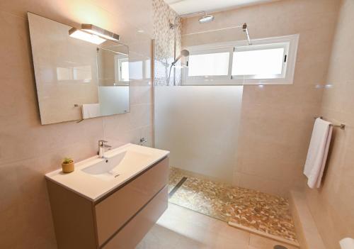 une salle de bain avec un lavabo et un miroir dans l'établissement Edificio Torre de Calpe, à Calp