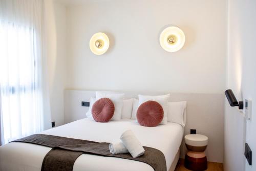 a bedroom with a white bed with red pillows on it at Citrea Santander in Santander