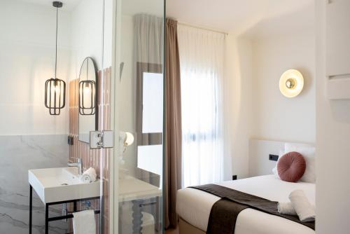 a bedroom with a bed and a sink and a mirror at Citrea Santander in Santander