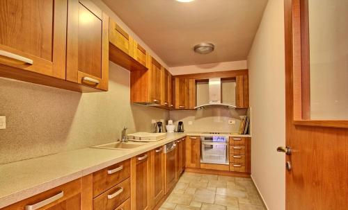 a kitchen with wooden cabinets and a sink at Avakas Sunset Villa in Paphos City