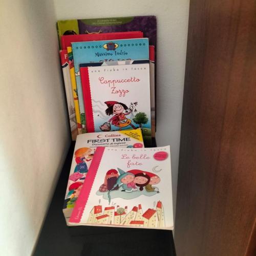 a group of books sitting on top of a shelf at Casa Matilde in Genova