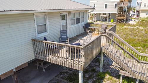 eine Terrasse mit Stühlen und einem Tisch auf einem Haus in der Unterkunft Beachside Bungalow in North Topsail Beach