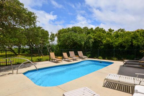 einen Pool mit Liegestühlen neben einem Zaun in der Unterkunft Bella Vita in Thomas Landing