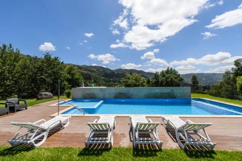 a swimming pool with lounge chairs and a swimming poolvisorvisor at Gerês Country Stays - Quinta dos Motas in Ventosa