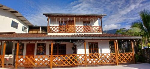 a house with a balcony on the front of it at Birdsong lodge in Mocoa