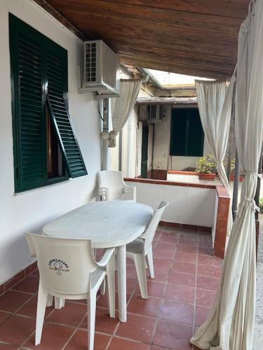 a white table and chairs on a patio at Casa Ondea in Marina di Pisa