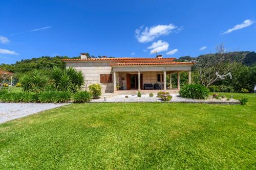 a small house with a green lawn in front of it at Gerês Country Stays - Quinta dos Motas in Ventosa