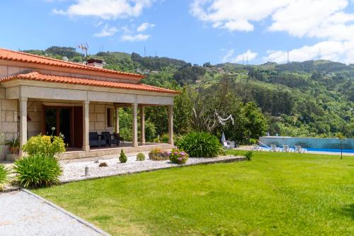 una casa con un patio verde con piscina en Gerês Country Stays - Quinta dos Motas, en Ventosa