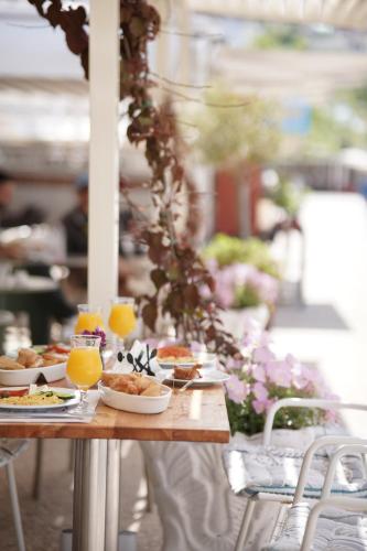 a table with plates of food and glasses of orange juice at Noemie Hotel in Himare