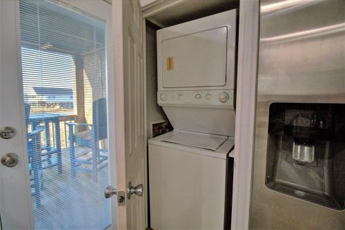 a kitchen with a white refrigerator and a microwave at Living on the Edge Too in North Topsail Beach