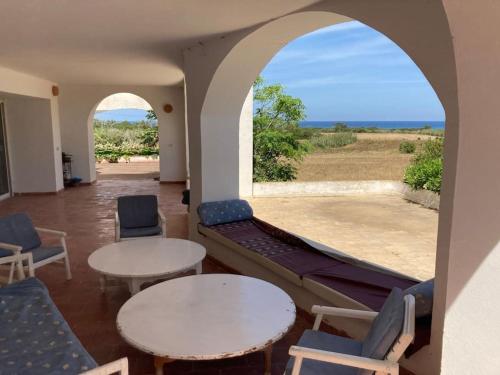 a living room with two tables and chairs and a couch at Maison front de mer à Kerkouen in Kerkouene