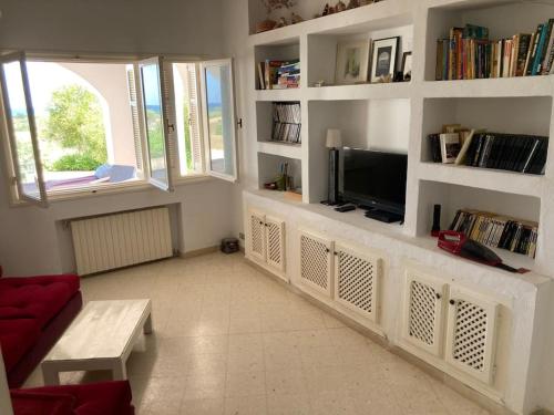 a living room with a couch and a tv at Maison front de mer à Kerkouen in Kerkouene
