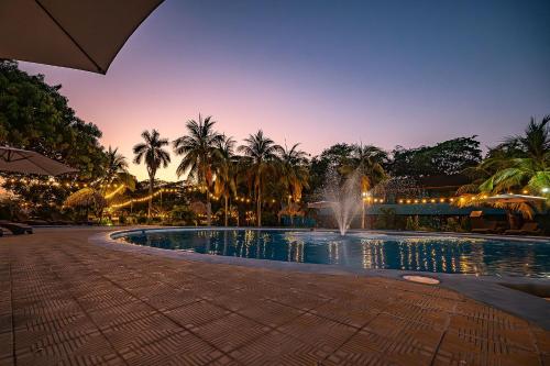 a fountain in the middle of a pool at night at Beach Break Resort & CR Surf Camp in Jacó