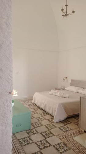 a white bedroom with a bed and a tile floor at Villa Nuova 1924 in Mottola