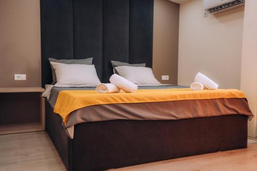 a bedroom with a large bed with a black headboard at Tim Apartmani in Ohrid