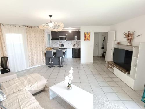 un salon avec un canapé blanc et une cuisine dans l'établissement Magnifique T3 - Grande Terrasse - Parking Privé, à Montpellier