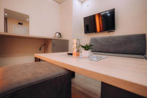 a kitchen with a table with a chair and a television at Tim Apartmani in Ohrid