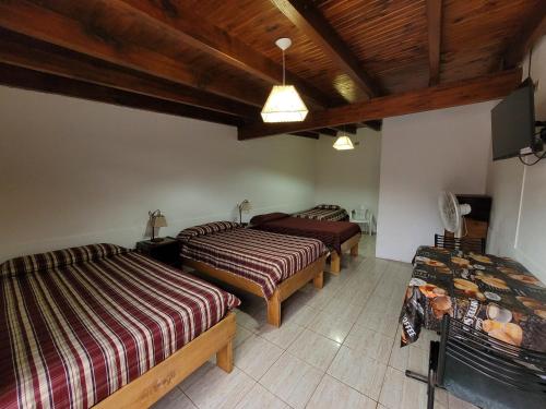 a bedroom with three beds and a wooden ceiling at Hotel Casa Grande in Pareditas