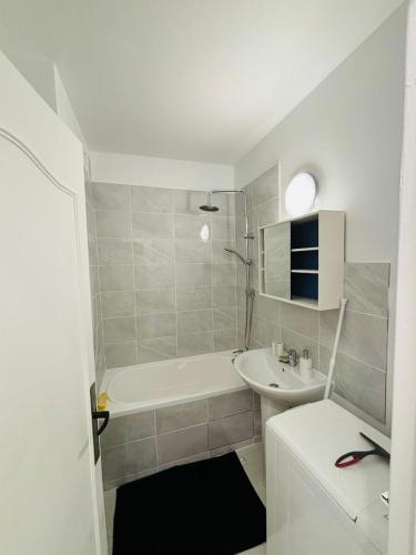 une salle de bain avec un lavabo, une baignoire et des toilettes dans l'établissement CosyRoom, à Limoges