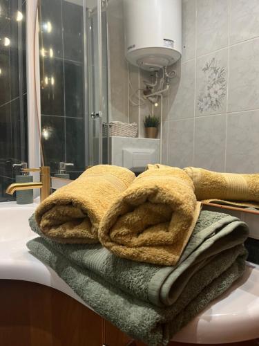 a pile of towels sitting on a counter in a bathroom at Apartament Piwna52 in Gdańsk