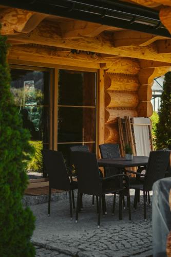 a table and chairs in front of a log cabin at Domki Trzy Korony in Sromowce Niżne