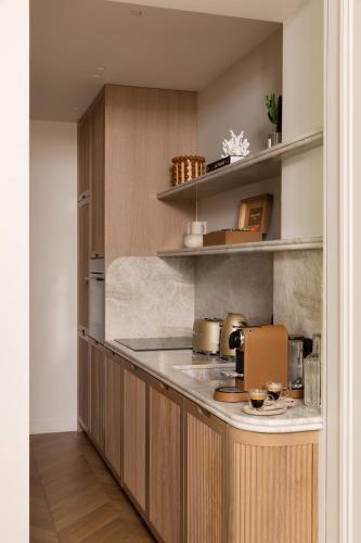 une cuisine avec des armoires en bois et un comptoir dans l'établissement HIGHSTAY - Luxury Serviced Apartments - Bourse, à Paris