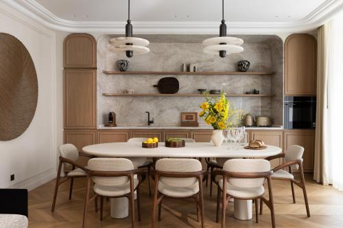 - une cuisine avec une table et des chaises blanches dans l'établissement HIGHSTAY - Luxury Serviced Apartments - Bourse, à Paris