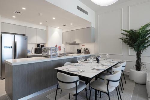 a dining room with a table and a kitchen at Luxury 4BR Burj Khalifa & Fountain Views in Dubai