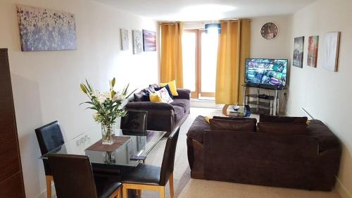 a living room with a couch and a table at KCS Birmingham City Apartment with Balcony/Parking in Birmingham
