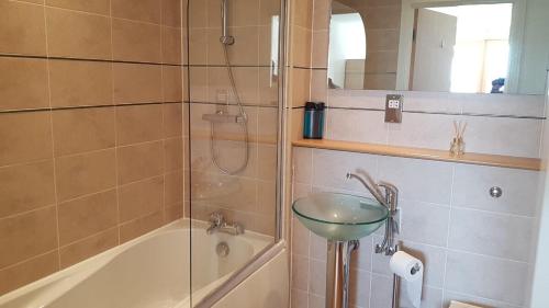 a bathroom with a shower and a sink and a tub at KCS Birmingham City Apartment with Balcony/Parking in Birmingham