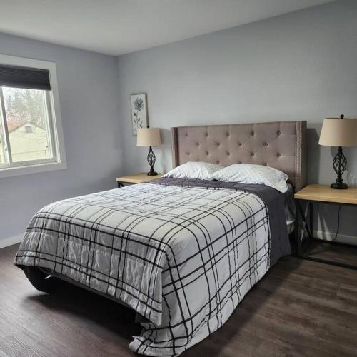 a bedroom with a bed and two tables and a window at Spacious House in Federay Way, WA - Close to everything! in Federal Way