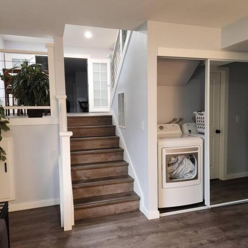 a living room with a staircase and a washing machine at Spacious House in Federay Way, WA - Close to everything! in Federal Way