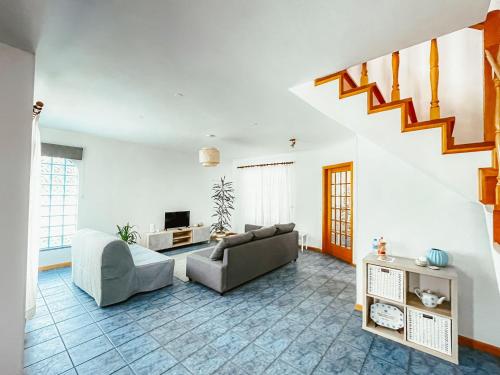 a living room with a couch and a tv at Casa Azul (Blue House) in Urzelina