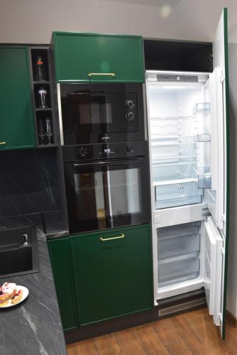 a green refrigerator with its door open in a kitchen at Apartmány Žakovce & SPA in Veľká Lomnica