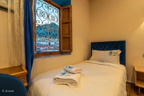 a small bedroom with a bed with towels on it at Dar Kisania in Chefchaouene
