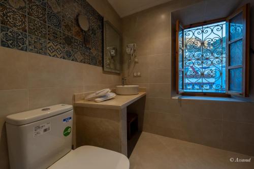 a bathroom with a toilet and a window at Dar Kisania in Chefchaouene