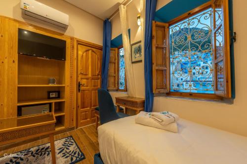 a bedroom with a bed and a window at Dar Kisania in Chefchaouene