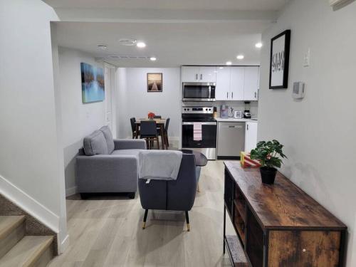 a living room and kitchen with a couch and a table at Beautiful Comfy Guest Suite in West EDM in Edmonton