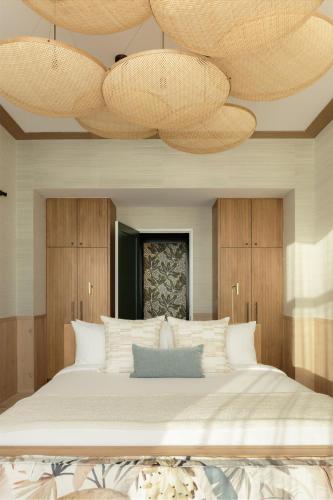 a bedroom with a large bed with two large chandeliers at Hotel Indigo Grand Cayman by IHG in Grand Cayman