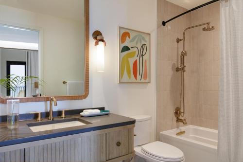 a bathroom with a sink and a toilet and a mirror at Hotel Indigo Grand Cayman by IHG in Grand Cayman