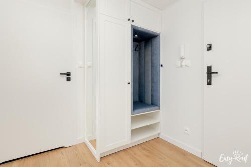 a closet with white cabinets and a blue door at Apartamenty Pinea z widokiem na morze Easy - Rent Apartments in Pobierowo